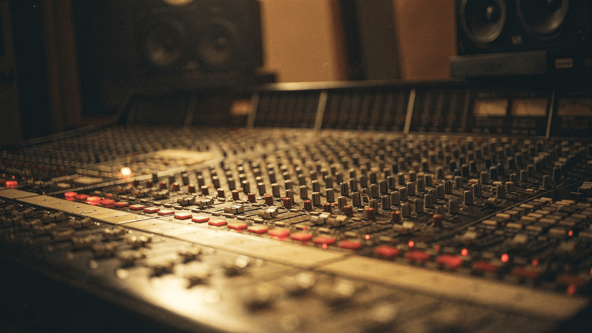 An analog mixing console in a dimly lit studio. Image generated with Artlist.